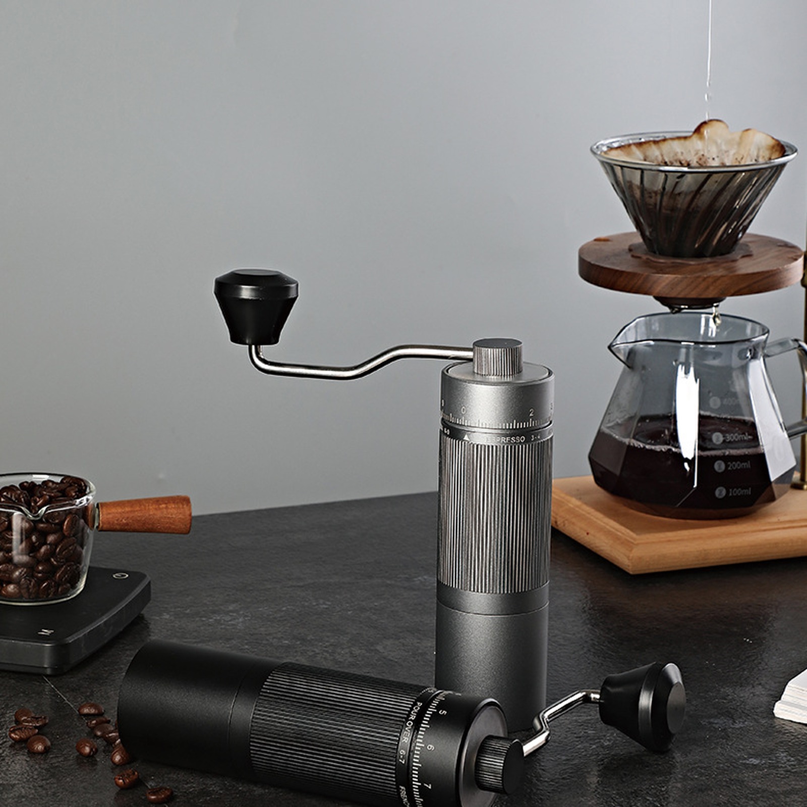 Black and grey grinders beside a pour-over brewer; grey finish shown for reference